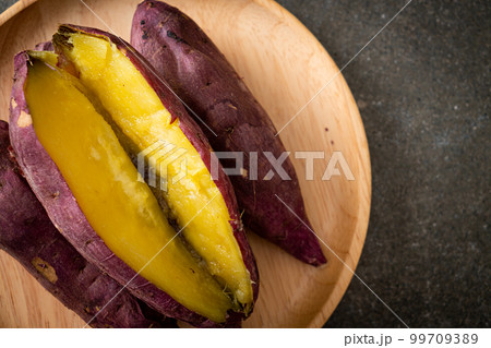Grilled or baked Japanese sweet potatoes on wood plate 99709389