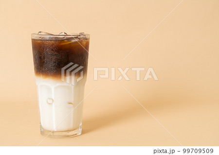 iced coffee with milk layer in glass 99709509