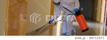 Person in hazmats are cleaned in corridor of hospital or public office 99712977