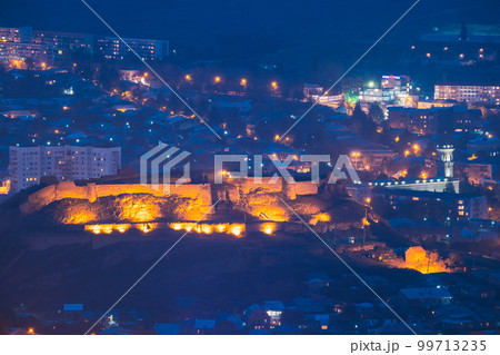 Medieval Citadel In Night Lights. Gori Fortress In Cityscape In Evening Illumination Under Blue Sky. Gori, Shida Kartli Region, Georgia. Travel Destination 99713235