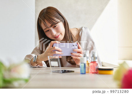 スマートフォンで化粧品を撮影する女性 99713280