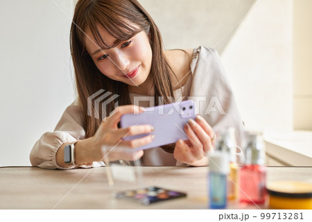 スマートフォンで化粧品を撮影する女性 スマートフォンで化粧品を撮影する女性 99713281