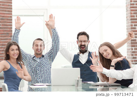 very happy business team sitting at the Desk very happy business team sitting at the Desk 99713471