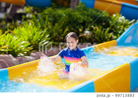 Kids on water slide in aqua park. Summer vacation Kids on water slide in aqua park. Summer vacation 99713883