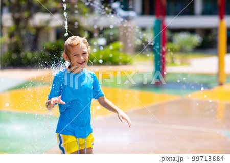 Child playing under tip bucket in water park. Child playing under tip bucket in water park. 99713884