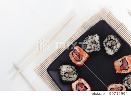 different types of Maki sushi on a black plate different types of Maki sushi on a black plate 99713994