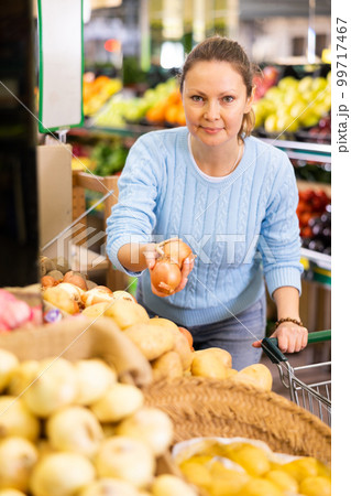 woman buy large onion in supermarket woman buy large onion in supermarket 99717467