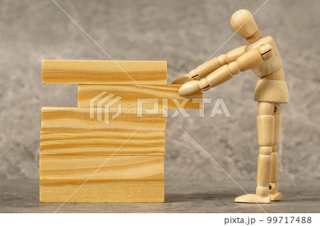 Dummy pulling out wood block from a tower 99717488