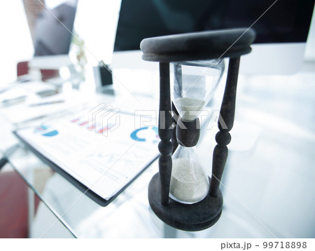 financial graph and the hourglass on the Desk 99718898