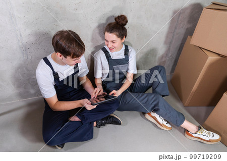 Couple in new home during repair works discussing about home design project looking repair plan on tablet. Happy family choosing new decorations and design. Home renovation DIY renew makeover concept 99719209