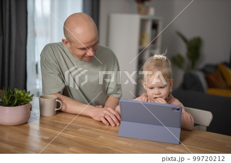 People with cochlear implant system. Kid study to hear with her father, learning with video on tablet. Installation cochlear implant on child girl ear for restores hearing. People with cochlear implant system. Kid study to hear with her father, learning with video on tablet. Installation cochlear implant on child girl ear for restores hearing. 99720212
