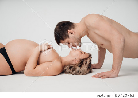 a passionate man and pregnan woman topless in black underwear on the floor a passionate man and pregnan woman topless in black underwear on the floor 99720763