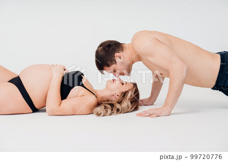 a loving and passionate man and pregnan woman in black underwear on the floor a loving and passionate man and pregnan woman in black underwear on the floor 99720776