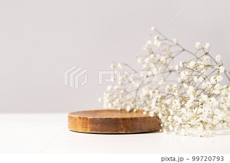 Beauty cosmetic product presentation scene made with a wooden plate and wild flowers. Summer mood background. Front view. Beauty cosmetic product presentation scene made with a wooden plate and wild flowers. Summer mood background. Front view. 99720793