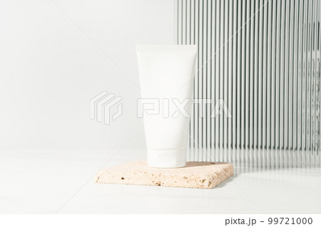 Empty white plastic mockup cosmetic, cream bottle standing on a bathroom shelf. Studio photography. 99721000