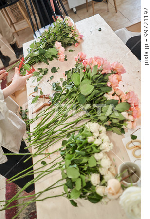 Florist prepares flowers. Fresh delivery in flower shop. European floral shop. Delivery fresh cut flower. 99721192