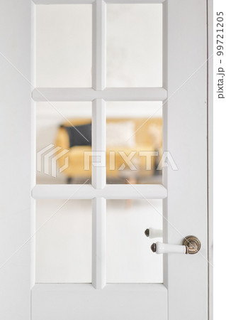 Old-style door, white - handle close up. The interior of a bright living room in a modern apartment. Old-style door, white - handle close up. The interior of a bright living room in a modern apartment. 99721205