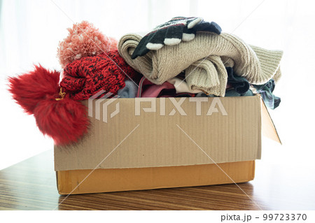 Donation box with used clothes at home to support help for poor people in the world. 99723370