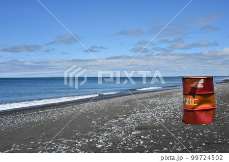 砂浜に漂着した赤いドラム缶　環境破壊　写真素材【撮影地：北海道北部】 99724502
