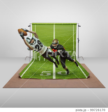 Competition. Two men, professional american football players in uniform playing over sports playground background. Concept of sport 99726170