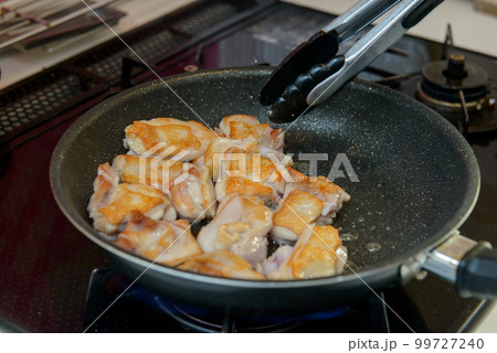 フライパンで鶏肉を焼いているシーン 99727240
