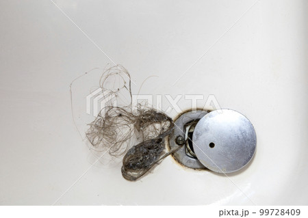 Shower drain is clogged with hair, Hair pile loss in a bathroom after wash hair in shower, cleaning bathroom and removing hair top view 99728409