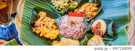 Nasi lemak, Nasi campur, Indonesian Balinese rice with potato fritter, sate lilit, fried tofu, spicy boiled eggs, and peanut BANNER, LONG FORMAT Nasi lemak, Nasi campur, Indonesian Balinese rice with potato fritter, sate lilit, fried tofu, spicy boiled eggs, and peanut BANNER, LONG FORMAT 99728899