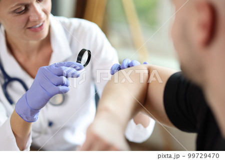 Female doctor examining male patient skin at consultation in medical clinic Female doctor examining male patient skin at consultation in medical clinic 99729470