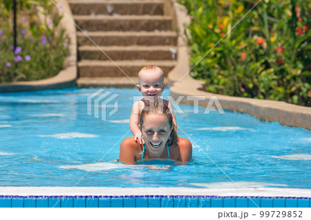 Portrait of boy having fun in pool with joyful mother. 99729852