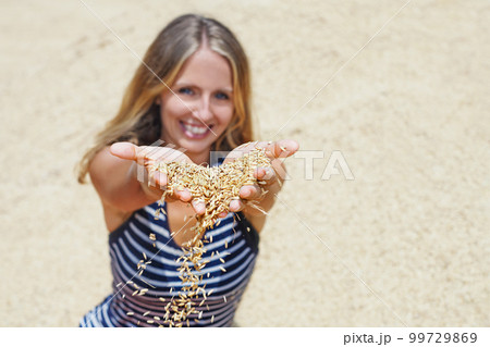 Woman with handful of raw rice grains in hands Woman with handful of raw rice grains in hands 99729869
