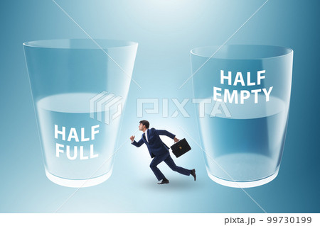 Businessman in half empty half full glass concept 99730199