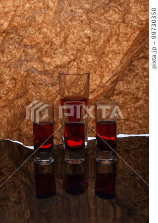 Still life with glassware with liquid on a reflective surface Still life with glassware with liquid on a reflective surface 99730350