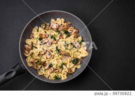 Delicious farfalle pasta with mushrooms, cheese and spinach with spices Delicious farfalle pasta with mushrooms, cheese and spinach with spices 99730822