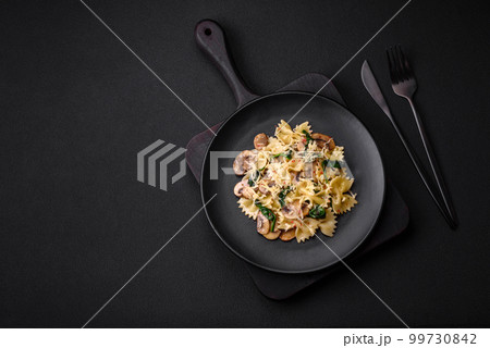 Delicious farfalle pasta with mushrooms, cheese and spinach with spices Delicious farfalle pasta with mushrooms, cheese and spinach with spices 99730842