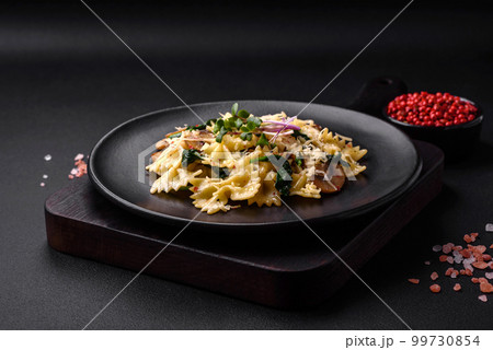 Delicious farfalle pasta with mushrooms, cheese and spinach with spices 99730854