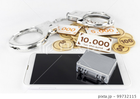 オモチャのお金とアタッシュケースと手錠とスマートフォン。マネーロンダリングのイメージ 99732115