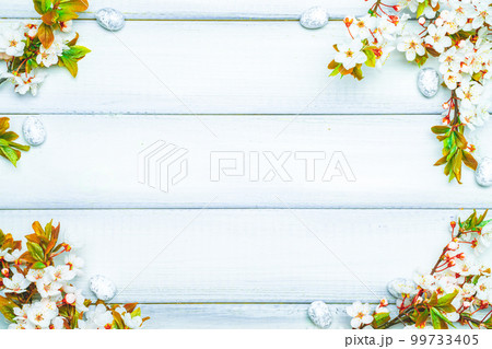 Easter eggs background. May flowers, white happy easter egg on wooden spring background. Easter card. Flat lay. 99733405