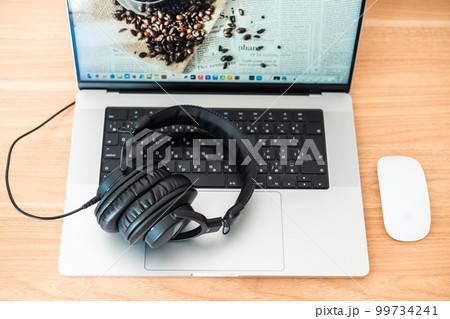 PCに置かれたヘッドフォン 99734241