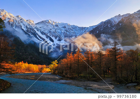 上高地の河童橋から眺めた朝焼けの梓川と冠雪の穂高連峰 上高地の河童橋から眺めた朝焼けの梓川と冠雪の穂高連峰 99736180