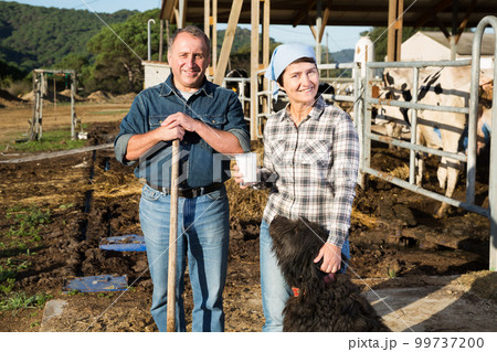 Couple farmers are standing with dog Couple farmers are standing with dog 99737200