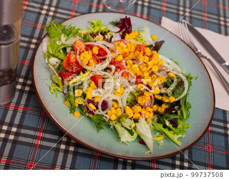 Delicious summer salad with onions, tomatoes and corn close up 99737508