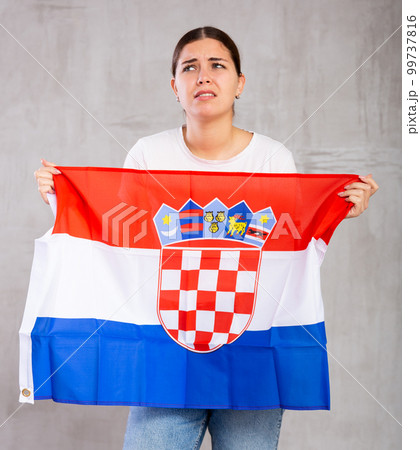 Irritated girl stands with flag of Croatia. Isolated on gray background Irritated girl stands with flag of Croatia. Isolated on gray background 99737816