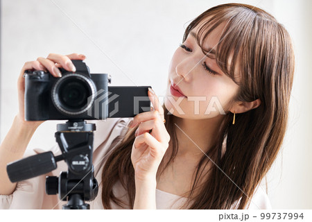 カメラを操作する女性 99737994