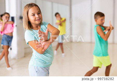 Young girls and boys performing modern dance in studio 99738282