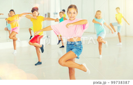 Young girls and boys performing dance in studio 99738387