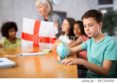 Female teacher showing english flag to kids in geography class 99738469