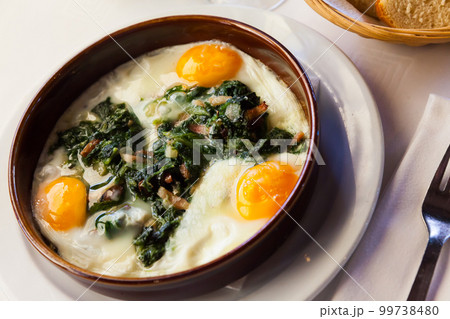 Fried eggs with spinach, raisins and ham, dish of Catalan cuisine Fried eggs with spinach, raisins and ham, dish of Catalan cuisine 99738480