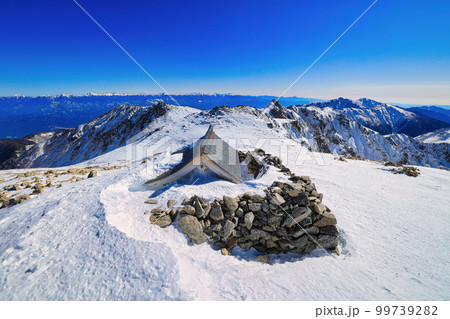 木曽駒ヶ岳頂上から空木岳へ続く冠雪の稜線 99739282