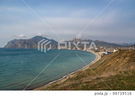 View of seaside resort city Koktebel , mountain Kara Dag from hill in spring. Crimea View of seaside resort city Koktebel , mountain Kara Dag from hill in spring. Crimea 99739516