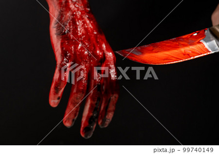 Man holding knife with bloody hand on black background. Man holding knife with bloody hand on black background. 99740149